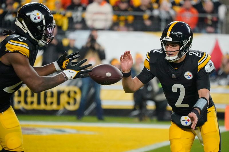 Pittsburgh Steelers quarterback Mason Rudolph (2) passes to Pittsburgh Steelers running back Najee Harris (22) during the first half of an NFL football game against the Cincinnati Bengals, Saturday, Dec. 23, 2023, in Pittsburgh. (AP Photo/Gene J. Puskar)