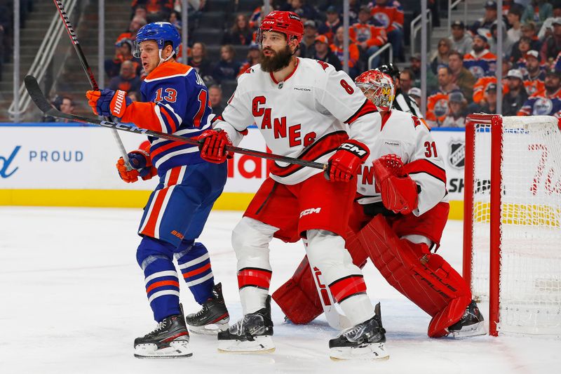 Oct 22, 2024; Edmonton, Alberta, CAN; Edmonton Oilers forward Mattias Janmark (13) battles with Carolina Hurricanes defensemen Brent Burns (8) in front of goaltender Frederik Andersen (31) during the first period at Rogers Place. Mandatory Credit: Perry Nelson-Imagn Images