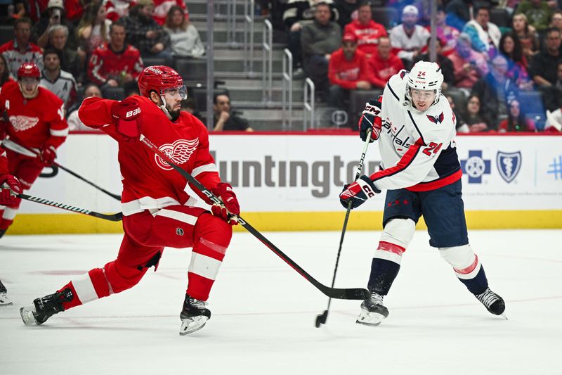 Feb 27, 2024; Detroit, Michigan, USA; Washington Capitals center Connor McMichael (24) shoots as Detroit Red Wings defenseman Jake Walman (96) defends during the third period at Little Caesars Arena. Mandatory Credit: Tim Fuller-USA TODAY Sports