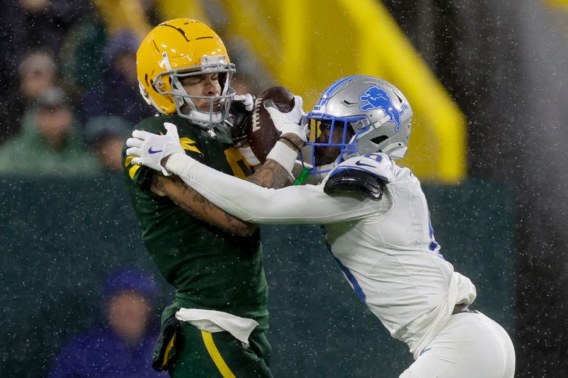 Green Bay Packers wide receiver Christian Watson, left, makes a catch next to Detroit Lions cornerback Terrion Arnold during the second half of an NFL football game Sunday, Nov. 3, 2024, in Green Bay, Wis. (AP Photo/Matt Ludtke)