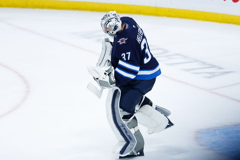 Nov 5, 2024; Winnipeg, Manitoba, CAN;  Winnipeg Jets goalie Connor Hellebuyck (37) celebrates his win against the Utah Hockey Club at the end of the third period at Canada Life Centre. Mandatory Credit: Terrence Lee-Imagn Images