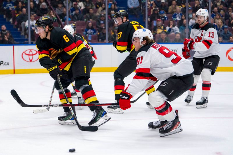Oct 30, 2024; Vancouver, British Columbia, CAN; Vancouver Canucks forward Brock Boeser (6) passes the puck around New Jersey Devils forward Dawson Mercer (91) during the first period at Rogers Arena. Mandatory Credit: Bob Frid-Imagn Images