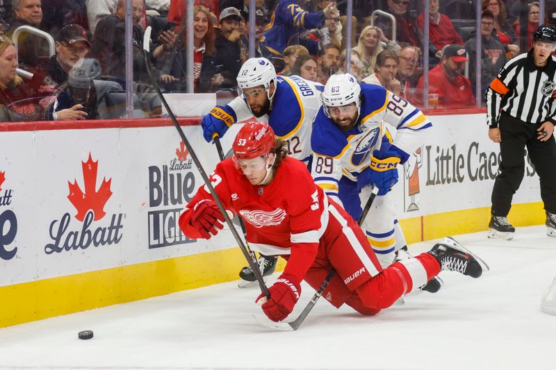 Nov 2, 2024; Detroit, Michigan, USA; Detroit Red Wings defenseman Moritz Seider (53), Buffalo Sabres right wing Alex Tuch (89) and left wing Jordan Greenway (12) fight for control of the puck in the third period of the game at Little Caesars Arena. Mandatory Credit: Brian Bradshaw Sevald-Imagn Images