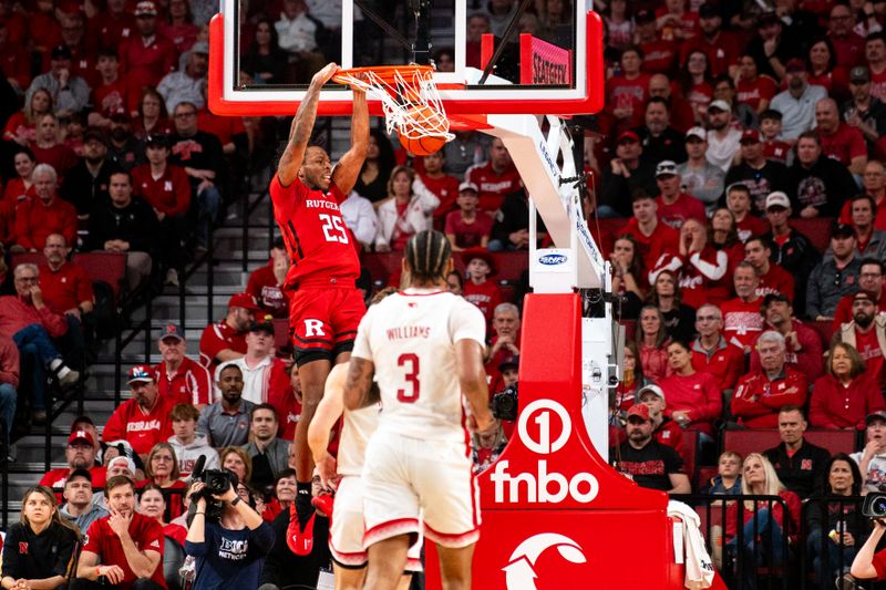 Mar 3, 2024; Lincoln, Nebraska, USA; Rutgers Scarlet Knights guard Jeremiah Williams (25) dunks the ball against Nebraska Cornhuskers guard Sam Hoiberg (1) and guard Brice Williams (3) during the first half at Pinnacle Bank Arena. Mandatory Credit: Dylan Widger-USA TODAY Sports