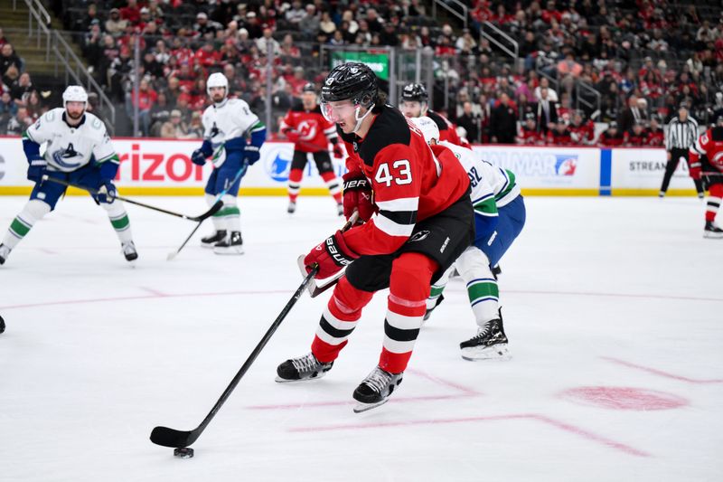Dec 14, 2025; Newark, New Jersey, USA; New Jersey Devils defenseman Luke Hughes (43) controls the puck against the Vancouver Canucks during the second period at Prudential Center. Mandatory Credit: John Jones-Imagn Images