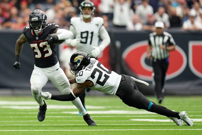 Houston Texans running back Dare Ogunbowale (33) runs from Jacksonville Jaguars safety Daniel Thomas (20) during the second half of an NFL football game, Sunday, Sept. 29, 2024, in Houston. (AP Photo/Eric Gay)