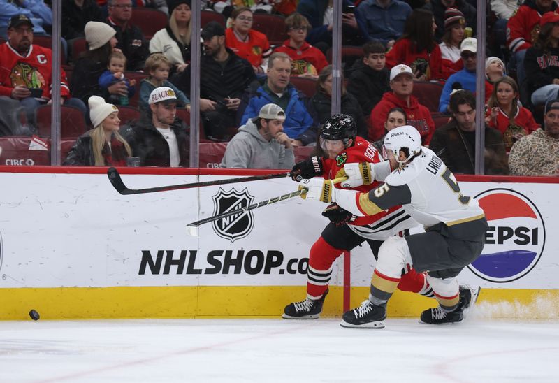 Jan 4, 2026; Chicago, Illinois, USA; Chicago Blackhawks center Ryan Donato (8) and Vegas Golden Knights defenseman Jeremy Lauzon (5) battle for control of the puck during the first period at United Center. Mandatory Credit: Talia Sprague-Imagn Images