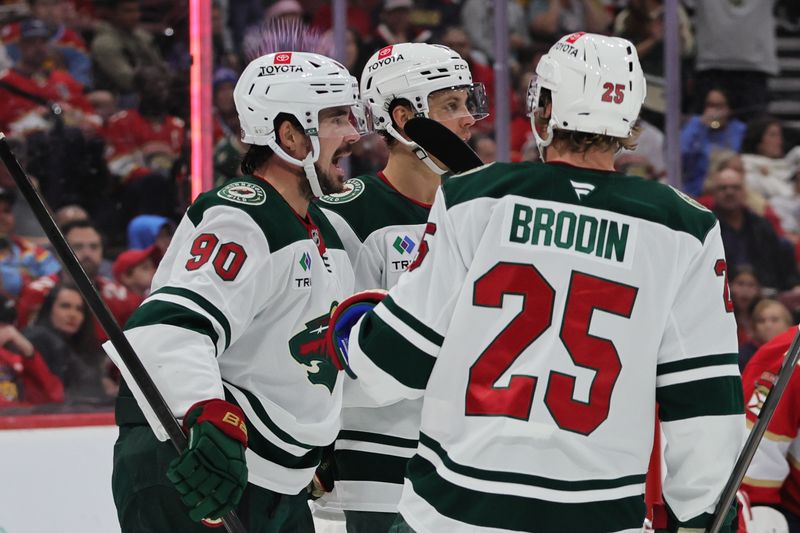 Oct 22, 2024; Sunrise, Florida, USA; Minnesota Wild center Marcus Johansson (90) celebrates with teammates after scoring against the Florida Panthers during the first period at Amerant Bank Arena. Mandatory Credit: Sam Navarro-Imagn Images