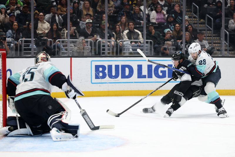 Apr 7, 2025; Los Angeles, California, USA;  Los Angeles Kings left wing Jeff Malott (39) skates with the puck as Seattle Kraken defenseman Joshua Mahura (28) defends during the second period at Crypto.com Arena. Mandatory Credit: Kiyoshi Mio-Imagn Images