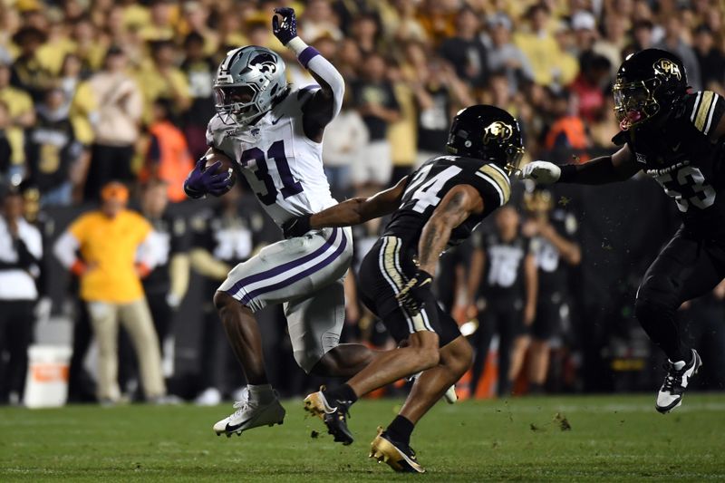 Oct 12, 2024; Boulder, Colorado, USA; Kansas State Wildcats running back DJ Giddens (31) breaks a tackle attempt from Colorado Buffaloes cornerback Preston Hodge (24) during the first half at Folsom Field. Mandatory Credit: Christopher Hanewinckel-Imagn Images