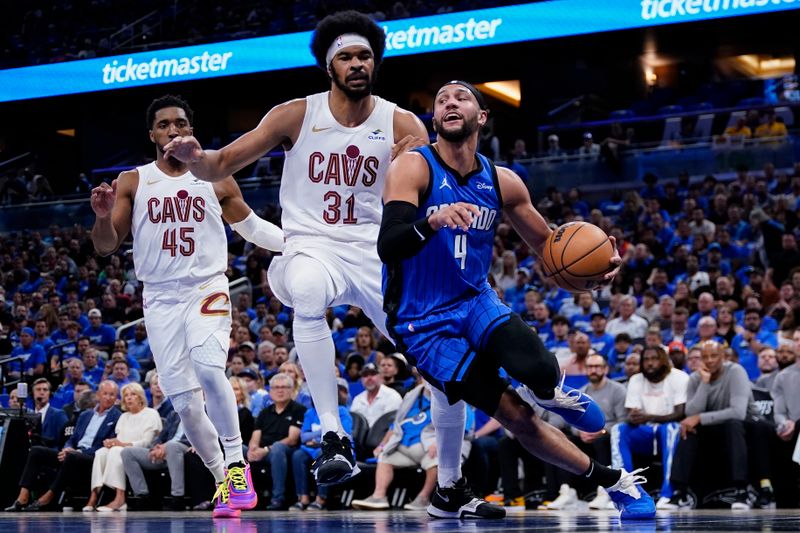 ORLANDO, FLORIDA - APRIL 25: Jalen Suggs #4 of the Orlando Magic dribbles the ball against Jarrett Allen #31 of the Cleveland Cavaliers during the first quarter of game three of the Eastern Conference First Round Playoffs at Kia Center on April 25, 2024 in Orlando, Florida. NOTE TO USER: User expressly acknowledges and agrees that, by downloading and or using this photograph, User is consenting to the terms and conditions of the Getty Images License Agreement. (Photo by Rich Storry/Getty Images)