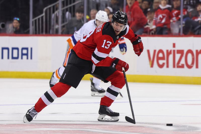 Oct 25, 2024; Newark, New Jersey, USA; New Jersey Devils center Nico Hischier (13) skates with the puck against the New York Islanders during the second period at Prudential Center. Mandatory Credit: Ed Mulholland-Imagn Images