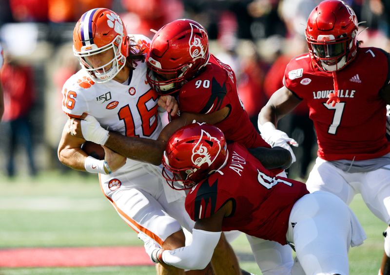 Oct 19, 2019; Louisville, KY, USA; Louisville Cardinals defensive lineman Jared Goldwire (90) and Louisville Cardinals linebacker C.J. Avery (9) sack Clemson Tigers quarterback Trevor Lawrence (16) during the first quarter of play at Cardinal Stadium. Mandatory Credit: Jamie Rhodes-USA TODAY Sports