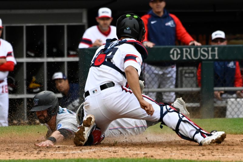 Jun 11, 2023; Chicago, Illinois, USA;  Miami Marlins shortstop Jon Berti (5) slides safely into home plate under Chicago White Sox catcher Seby Zavala (44) during the ninth inning at Guaranteed Rate Field. Mandatory Credit: Matt Marton-USA TODAY Sports