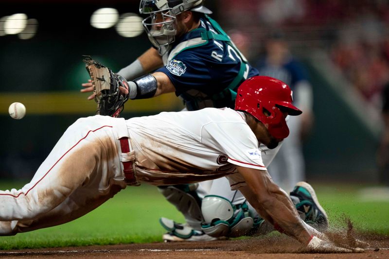 Sep 6, 2023; Cincinnati, Ohio, USA; Cincinnati Reds right fielder Will Benson (30) scores on a sacrifice fly ball hit by Cincinnati Reds center fielder TJ Friedl (not pictured) as Seattle Mariners catcher Cal Raleigh (29) attempts to stop him in the fifth inning of the MLB baseball game between the Cincinnati Reds and the Seattle Mariners at Great American Ball Park. Mandatory Credit: Albert Cesare-USA TODAY Sports