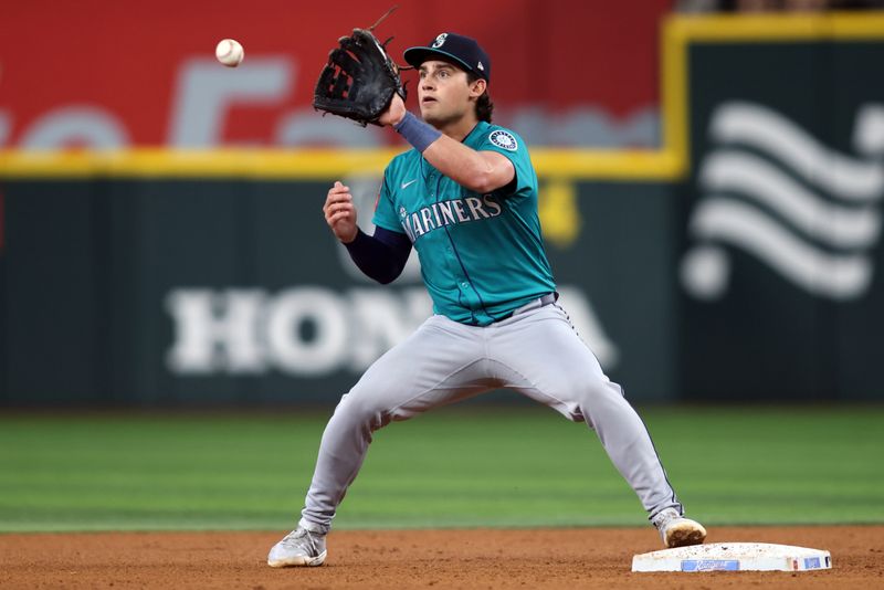 Jun 29, 2025; Arlington, Texas, USA; Seattle Mariners second base Cole Young (2) turns a double play during the fourth inning against the Texas Rangers at Globe Life Field. Mandatory Credit: Tim Heitman-Imagn Images