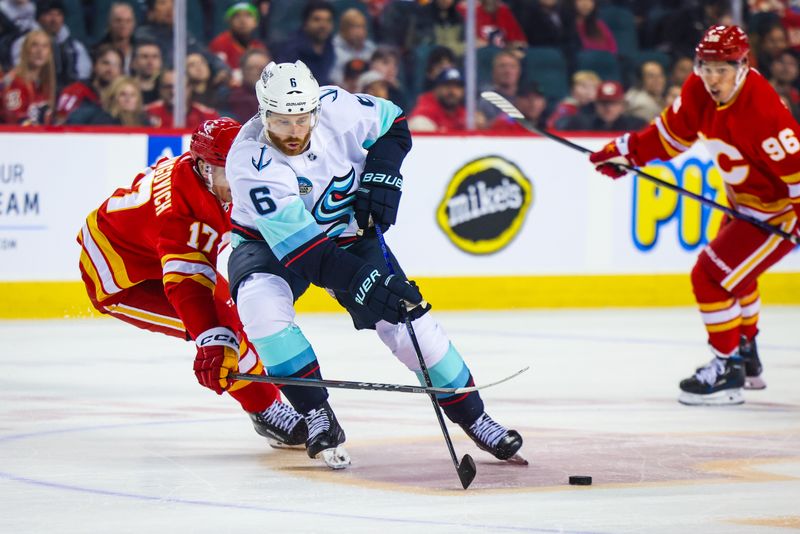 Mar 4, 2024; Calgary, Alberta, CAN; Seattle Kraken defenseman Adam Larsson (6) and Calgary Flames center Yegor Sharangovich (17) battles for the puck during the third period at Scotiabank Saddledome. Mandatory Credit: Sergei Belski-USA TODAY Sports