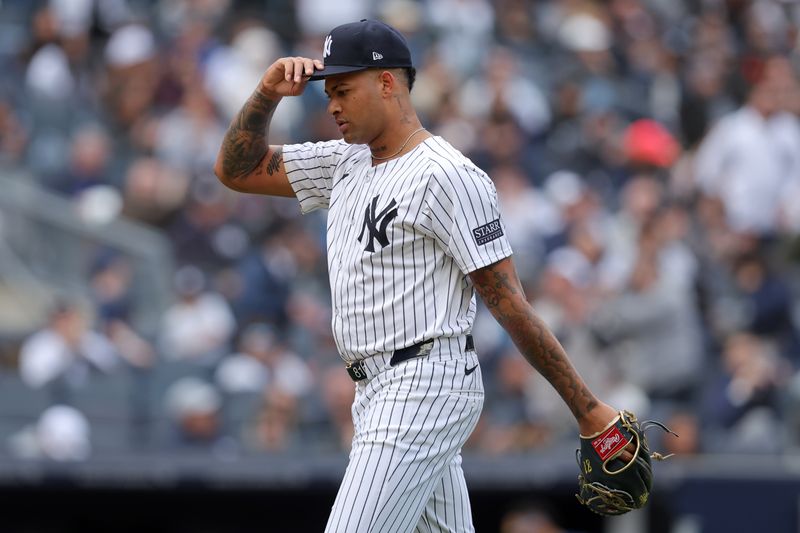 Apr 21, 2024; Bronx, New York, USA; New York Yankees starting pitcher Luis Gil (81) adjusts his cap as he walks off the field after being taken out of the game during the sixth inning against the Tampa Bay Rays at Yankee Stadium. Mandatory Credit: Brad Penner-USA TODAY Sports