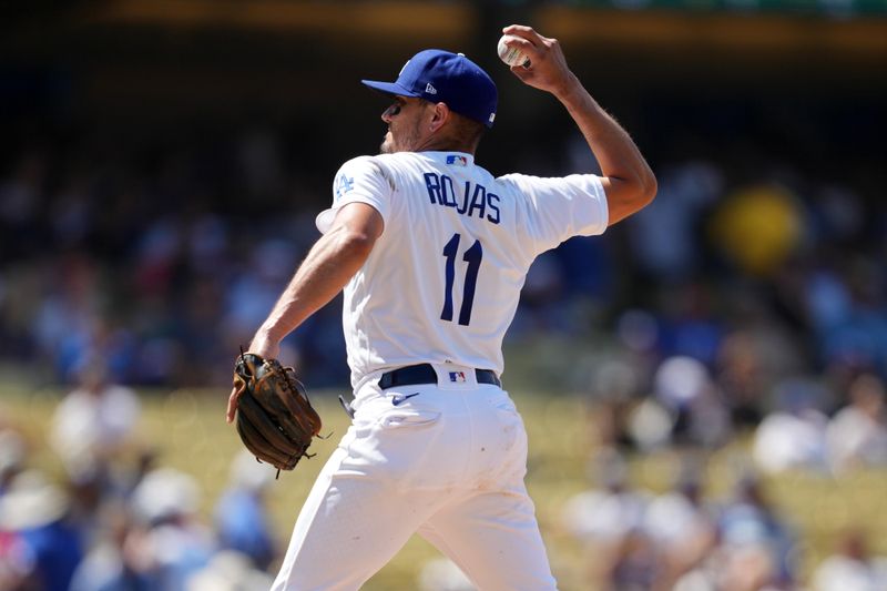 Jul 30, 2023; Los Angeles, California, USA; Los Angeles Dodgers shortstop Miguel Rojas (11) pitches in the ninth inning against the Cincinnati Reds at Dodger Stadium. Mandatory Credit: Kirby Lee-USA TODAY Sports