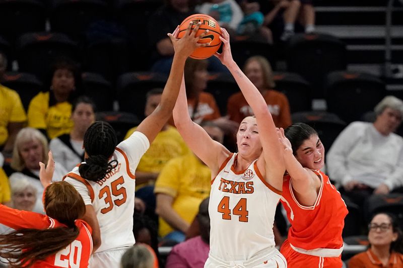 Dec 29, 2024; Austin, Texas, USA; Texas Longhorns forwards Taylor Jones (44) and Madison Booker (35) reach for a rebound against Rio Grande Valley Vaqueros forward Charlotte O'Keefe (1) during the second half at Moody Center. Mandatory Credit: Scott Wachter-Imagn Images