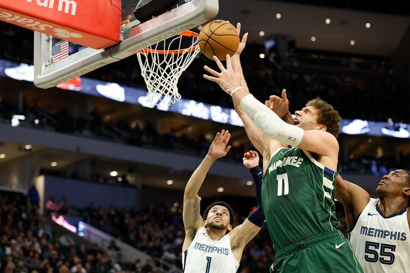 MILWAUKEE, WISCONSIN - APRIL 03: Brook Lopez #11 of the Milwaukee Bucks is fouled going up for a shot during the second half of the game against the Memphis Grizzlies at Fiserv Forum on April 03, 2024 in Milwaukee, Wisconsin. NOTE TO USER: User expressly acknowledges and agrees that, by downloading and or using this photograph, User is consenting to the terms and conditions of the Getty Images License Agreement. (Photo by John Fisher/Getty Images)