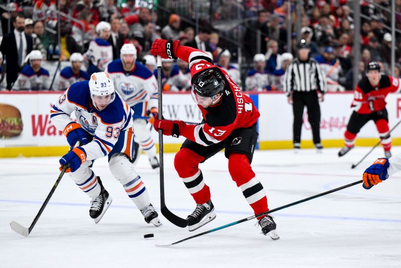 Oct 18, 2025; Newark, New Jersey, USA; New Jersey Devils center Nico Hischier (13) skates with the puck while defended by Edmonton Oilers center Ryan Nugent-Hopkins (93) during the second period at Prudential Center. Mandatory Credit: John Jones-Imagn Images