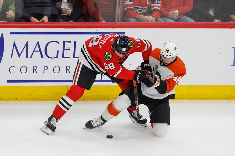 Feb 21, 2024; Chicago, Illinois, USA; Chicago Blackhawks right wing MacKenzie Entwistle (58) battles for the puck with Philadelphia Flyers center Morgan Frost (48) during the first period at United Center. Mandatory Credit: Kamil Krzaczynski-USA TODAY Sports