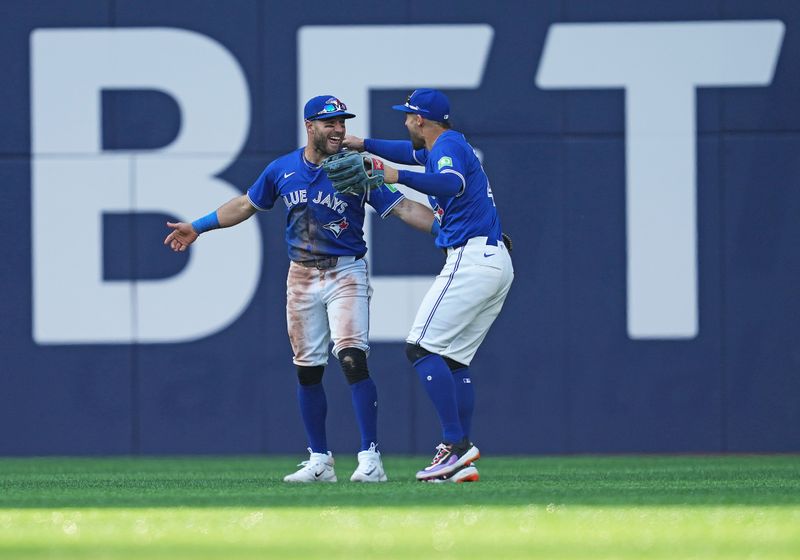 May 20, 2024; Toronto, Ontario, CAN; Toronto Blue Jays centre fielder Kevin Kiermaier (39) catches a fly ball for the final out and celebrates the win with right fielder George Springer (4) against the Chicago White Sox during the ninth inning at Rogers Centre. Mandatory Credit: Nick Turchiaro-USA TODAY Sports