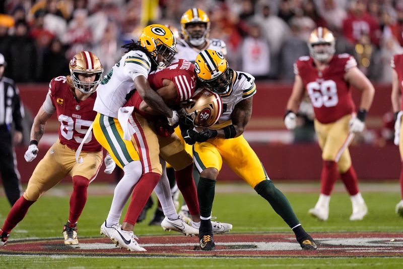 San Francisco 49ers wide receiver Jauan Jennings, middle, tackled by Green Bay Packers safety Darnell Savage, left, and linebacker Quay Walker during the first half of an NFL football NFC divisional playoff game Saturday, Jan. 20, 2024, in Santa Clara, Calif. (AP Photo/Godofredo A. Vásquez)