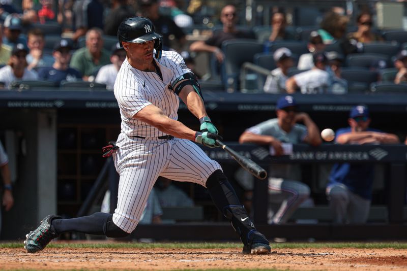 Aug 11, 2024; Bronx, New York, USA; New York Yankees designated hitter Giancarlo Stanton (27) hits a three run home run during the fifth inning against the Texas Rangers at Yankee Stadium. Mandatory Credit: Vincent Carchietta-USA TODAY Sports