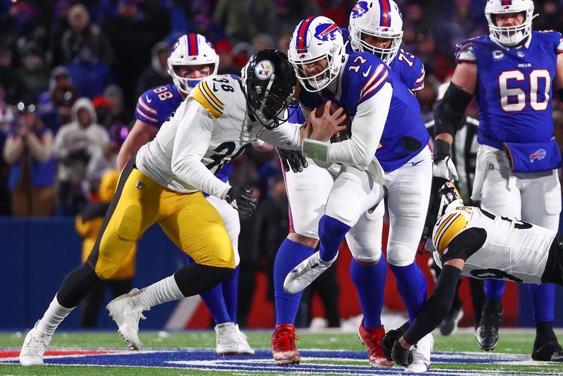 Buffalo Bills quarterback Josh Allen (17) carries the ball against Pittsburgh Steelers linebacker Mykal Walker (38) during the second half of an NFL wild-card playoff football game, Monday, Jan. 15, 2024, in Buffalo, N.Y. (AP Photo/Jeffrey T. Barnes)