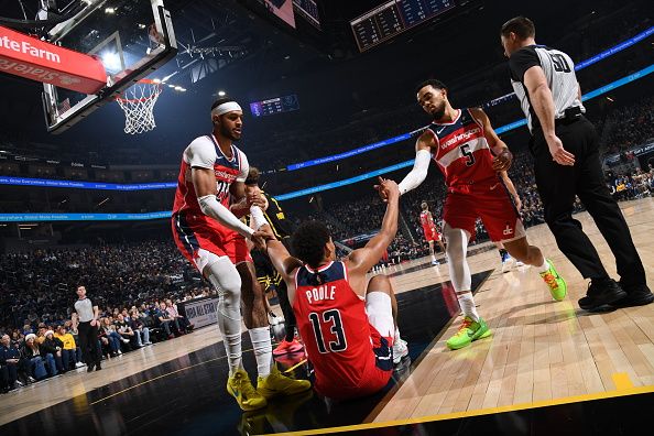 SAN FRANCISCO, CA - DECEMBER 22: Daniel Gafford #21 and Tyus Jones #5 help up Jordan Poole #13 of the Washington Wizards during the game against the Golden State Warriors on December 22, 2023 at Chase Center in San Francisco, California. NOTE TO USER: User expressly acknowledges and agrees that, by downloading and or using this photograph, user is consenting to the terms and conditions of Getty Images License Agreement. Mandatory Copyright Notice: Copyright 2023 NBAE (Photo by Noah Graham/NBAE via Getty Images)