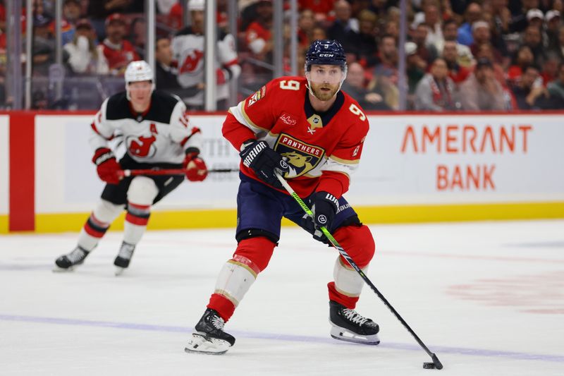 Nov 14, 2024; Sunrise, Florida, USA;  Florida Panthers center Sam Bennett (9) moves the puck against the New Jersey Devils during the second period at Amerant Bank Arena. Mandatory Credit: Sam Navarro-Imagn Images