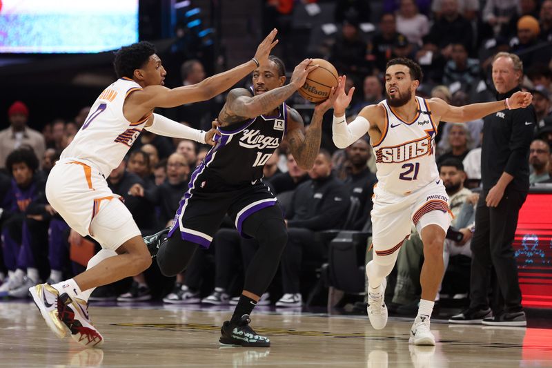 SACRAMENTO, CALIFORNIA - NOVEMBER 13: DeMar DeRozan #10 of the Sacramento Kings is guarded by Ryan Dunn #0 and Tyus Jones #21 of the Phoenix Suns in the first half at Golden 1 Center on November 13, 2024 in Sacramento, California. NOTE TO USER: User expressly acknowledges and agrees that, by downloading and/or using this photograph, user is consenting to the terms and conditions of the Getty Images License Agreement.  (Photo by Ezra Shaw/Getty Images)