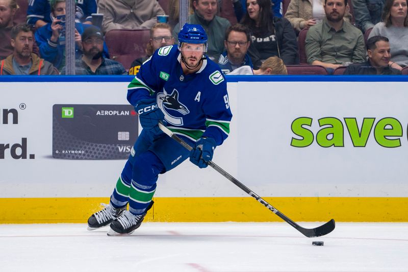 Oct 9, 2024; Vancouver, British Columbia, CAN; Vancouver Canucks forward J.T. Miller (9) handles the puck against the Calgary Flames during the first period at Rogers Arena. Mandatory Credit: Bob Frid-Imagn Images