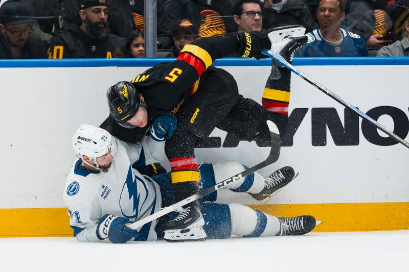 Mar 19, 2026; Vancouver, British Columbia, CAN; Vancouver Canucks defenseman Tom Willander (5) checks Tampa Bay Lightning forward Anthony Cirelli (71) in the first period at Rogers Arena. Mandatory Credit: Bob Frid-Imagn Images