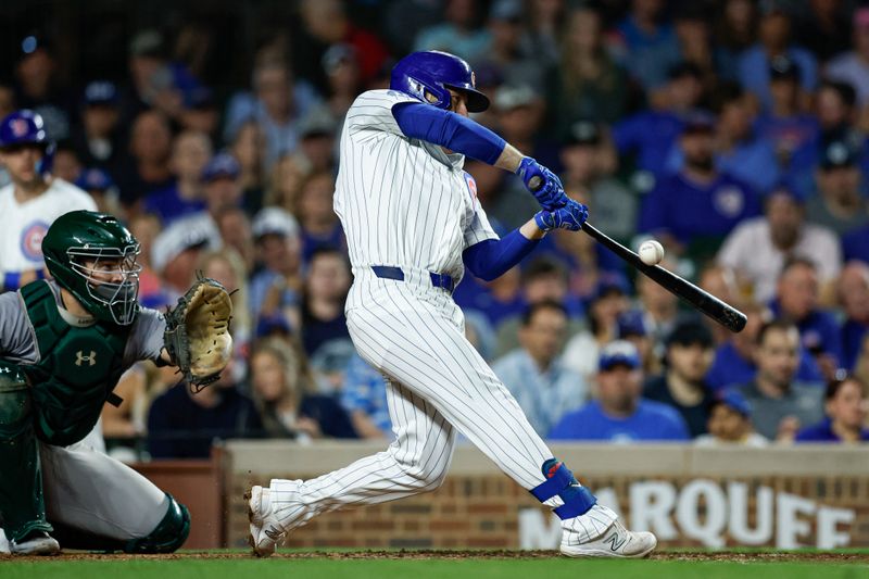 Sep 17, 2024; Chicago, Illinois, USA; Chicago Cubs first baseman Michael Busch (29) hits an RBI-single against the Oakland Athletics during the third inning at Wrigley Field. Mandatory Credit: Kamil Krzaczynski-Imagn Images