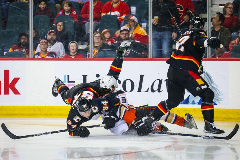 Apr 2, 2024; Calgary, Alberta, CAN; Anaheim Ducks center Mason McTavish (23) collides with Calgary Flames defenseman Brayden Pachal (94) and defenseman MacKenzie Weegar (52) during the second period at Scotiabank Saddledome. Mandatory Credit: Sergei Belski-USA TODAY Sports