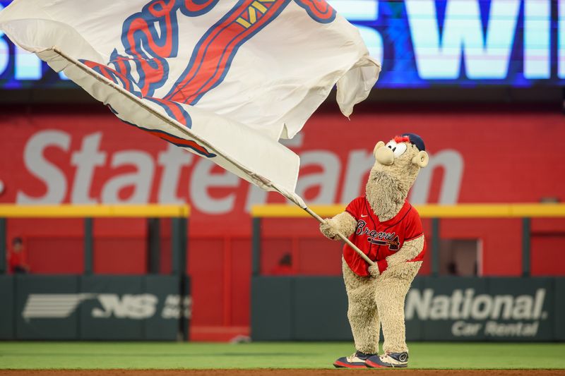 Jun 14, 2024; Atlanta, Georgia, USA; Atlanta Braves mascot Blooper waves a flag after a victory against the Tampa Bay Rays at Truist Park. Mandatory Credit: Brett Davis-USA TODAY Sports