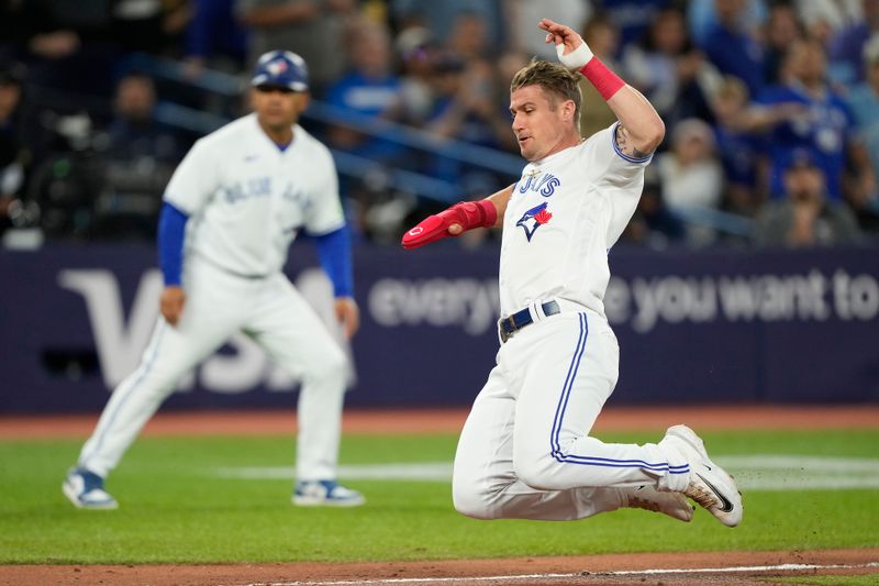 Sep 8, 2023; Toronto, Ontario, CAN; Toronto Blue Jays pinch runner Tyler Heineman (55) slides into home on a single hit by Toronto Blue Jays shortstop Bo Bichette (not pictured) during the seventh inning against the Kansas City Royals at Rogers Centre. Mandatory Credit: John E. Sokolowski-USA TODAY Sports