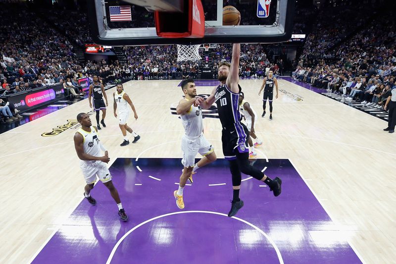 SACRAMENTO, CALIFORNIA - MARCH 31: Domantas Sabonis #10 of the Sacramento Kings dunks the ball against Omer Yurtseven #77 of the Utah Jazz in the second quarter at Golden 1 Center on March 31, 2024 in Sacramento, California. NOTE TO USER: User expressly acknowledges and agrees that, by downloading and or using this photograph, User is consenting to the terms and conditions of the Getty Images License Agreement. (Photo by Lachlan Cunningham/Getty Images)