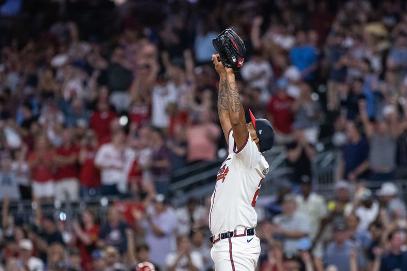 Aug 22, 2024; Cumberland, Georgia, USA; Atlanta Braves pitcher Raisel Iglesias (26) celebrates after the last pitch in the game against the Philadelphia Phillies at Truist Park. Mandatory Credit: Jordan Godfree-USA TODAY Sports