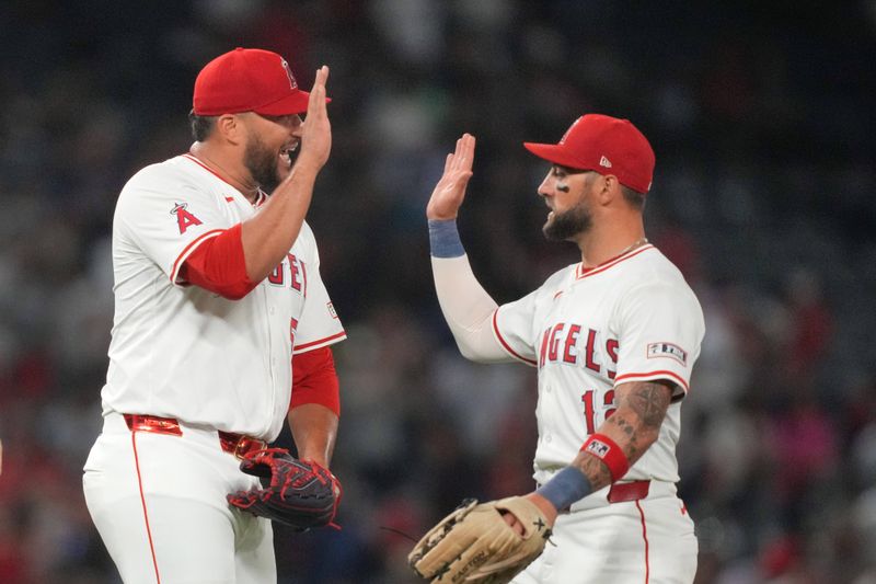 Jul 10, 2024; Anaheim, California, USA; Los Angeles Angels relief pitcher Carlos Estevez (53) celebrates with right fielder Kevin Pillar (12) after a game against the Texas Rangers at Angel Stadium. Mandatory Credit: Kirby Lee-USA TODAY Sports