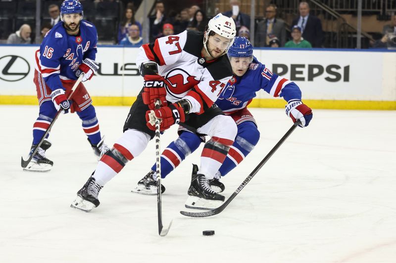 Mar 18, 2026; New York, New York, USA;  New Jersey Devils left wing Paul Cotter (47) and New York Rangers defenseman Will Borgen (17) battle for control of the puck in the second period at Madison Square Garden. Mandatory Credit: Wendell Cruz-Imagn Images