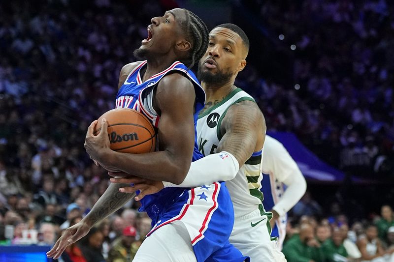 PHILADELPHIA, PENNSYLVANIA - OCTOBER 23: Tyrese Maxey #0 of the Philadelphia 76ers drives to the basket against Damian Lillard #0 of the Milwaukee Bucks in the first half at the Wells Fargo Center on October 23, 2024 in Philadelphia, Pennsylvania. NOTE TO USER: User expressly acknowledges and agrees that, by downloading and/or using this photograph, user is consenting to the terms and conditions of the Getty Images License Agreement. (Photo by Mitchell Leff/Getty Images)