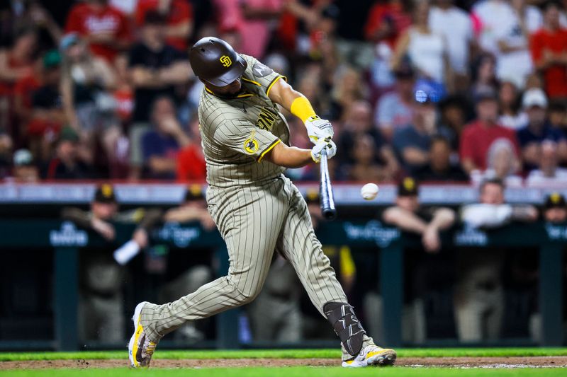 Jun 27, 2025; Cincinnati, Ohio, USA; San Diego Padres catcher Elias Diaz (17) hits a double in the ninth inning against the Cincinnati Reds at Great American Ball Park. Mandatory Credit: Katie Stratman-Imagn Images