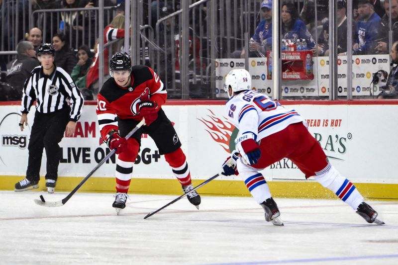 Nov 18, 2023; Newark, New Jersey, USA; New Jersey Devils center Michael McLeod (20) passes the puck against New York Rangers defenseman Erik Gustafsson (56) during the second period at Prudential Center. Mandatory Credit: John Jones-USA TODAY Sports