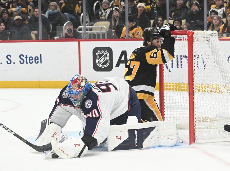 Jan 17, 2026; Pittsburgh, Pennsylvania, USA;  Pittsburgh Penguins right wing Rickard Rakell (67) crashes into the net by Columbus Blue Jackets goalie Elvis Merzlikins (90) during the first period at PPG Paints Arena. Mandatory Credit: Philip G. Pavely-Imagn Images