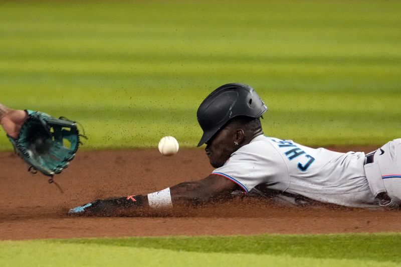 May 9, 2023; Phoenix, Arizona, USA; Miami Marlins center fielder Jazz Chisholm Jr. (2) slides into second base safely for a steal ahead of a throw to Arizona Diamondbacks second baseman Ketel Marte (4) during the fifth inning at Chase Field. Mandatory Credit: Joe Camporeale-USA TODAY Sports