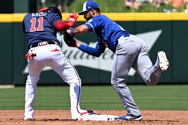 Mar 20, 2024; North Port, Florida, USA; Atlanta Braves shortstop Orlando Arcia (11) gets back to second base as Toronto Blue Jays shortstop Isiah Kiner-Falefa (7) catches the ball in the third inning of the spring training game  at CoolToday Park. Mandatory Credit: Jonathan Dyer-USA TODAY Sports